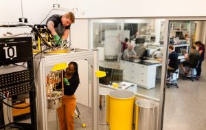 Institut_quantique_un_technicien_et_une_etudiante_qui_prépare_une_experimentation